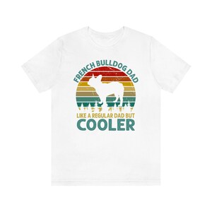 May include: White t-shirt with a vintage-style graphic of a French Bulldog silhouette in front of a sunset. The text reads "French Bulldog Dad Like a Regular Dad But Cooler".