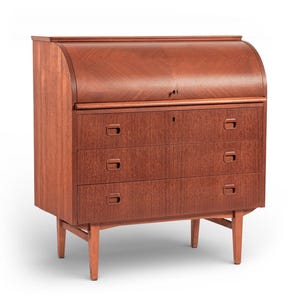 May include: A mid-century modern wooden desk with a roll-top and three drawers. The desk is made of reddish-brown wood and has a keyhole on the front. The desk is supported by four legs.