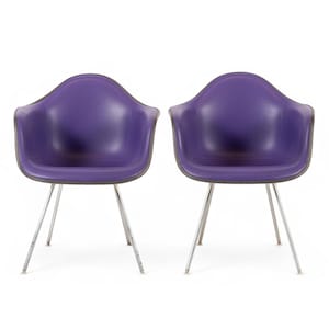 May include: A pair of armchairs featuring deep purple molded shells with smooth, curved backrests and integrated armrests. Each chair is supported by four slender, metallic silver legs that angle outward from the center to provide stability.