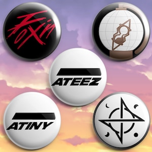 Könnte beinhalten: Ein Set aus fünf runden Ansteckbuttons mit verschiedenen Motiven. Einer ist schwarz mit rotem Text, einer zeigt einen Globus mit einer Sanduhr, einer ist weiß mit dem schwarzen Text ATEEZ, einer ist weiß mit dem schwarzen Text ATINY und einer ist weiß mit einem schwarzen Sternsymbol.
