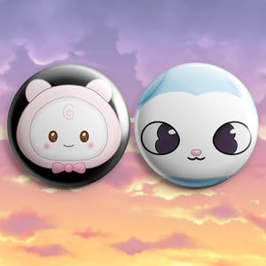 Pode incluir: Dois botões circulares com rostos de personagens de desenhos animados. O botão esquerdo tem um fundo preto com uma criatura rosa pálido usando uma gravata borboleta. O botão direito é branco e azul claro, exibindo uma criatura com olhos escuros.
