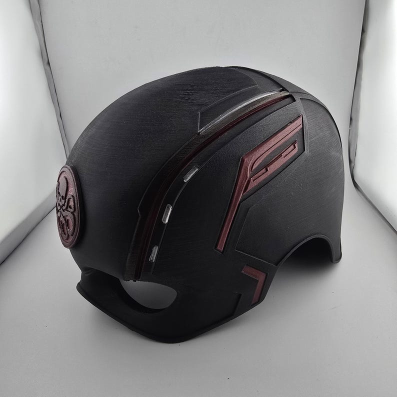 May include: Black helmet with red and white accents. The helmet has a red and white design on the side and a black and white symbol on the front.