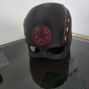 May include: Black helmet with a red Hydra logo. The helmet has red stripes on the sides.