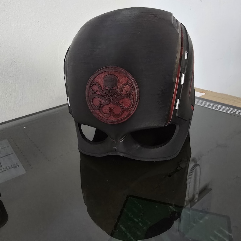 May include: Black helmet with a red Hydra logo. The helmet has red stripes on the sides.
