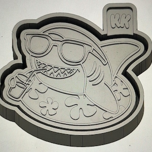 May include: A gray shark wearing sunglasses and drinking from a cup with a straw. The shark is surrounded by a border with the initials "KK" in the upper right corner. The shark is wearing sunglasses and has a toothy grin.