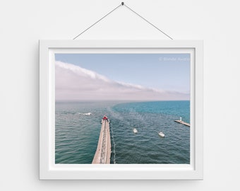 May include: An aerial view of a pier extending into a body of water. The pier is made of concrete and has a red lighthouse at the end. There are boats in the water and a cloud formation in the sky. The text "© Blondie Aviation" is in the upper right corner of the image.