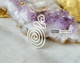May include: Silver spiral ear cuff with a delicate design. The cuff is made of a single piece of wire that is twisted and shaped into a spiral. The ear cuff is shown on a purple amethyst crystal background.
