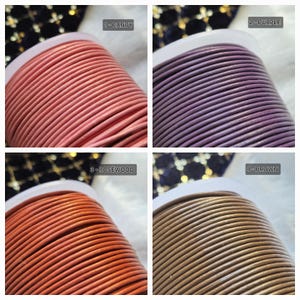 Pode incluir: Quatro carretéis de cordão de couro em diferentes cores: rosa doce, roxo, laranja pau-rosa e marrom. Cada carretel é etiquetado com um número e um nome de cor.
