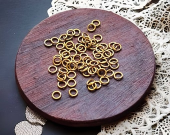 Puede incluir: Primer plano de un plato de madera con una gran cantidad de pequeños anillos de salto de color dorado. Los anillos están dispersos aleatoriamente en el plato.
