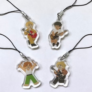 May include: Four clear acrylic keychains featuring cartoon characters playing musical instruments. Each keychain has a black string attached. The characters are holding a guitar, a bass guitar, a drumstick, and a microphone.