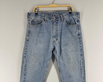 May include: Light blue denim jeans with a classic straight leg fit. The jeans have a button fly and five pockets.