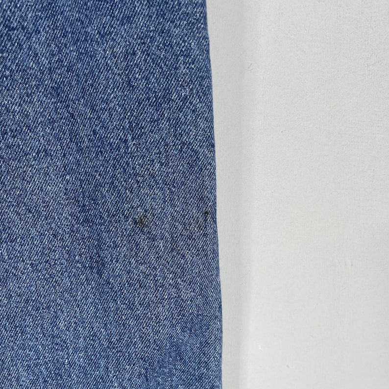 K&ouml;nnte beinhalten: Nahaufnahme eines blauen Jeansstoffs mit einer subtilen Textur. Der Stoff hat einen leichten Glanz und wirkt weich.