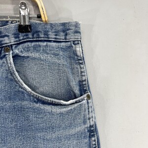 May include: A pair of light blue denim jeans with a front pocket. The jeans have a faded look and are made of a soft, comfortable material.