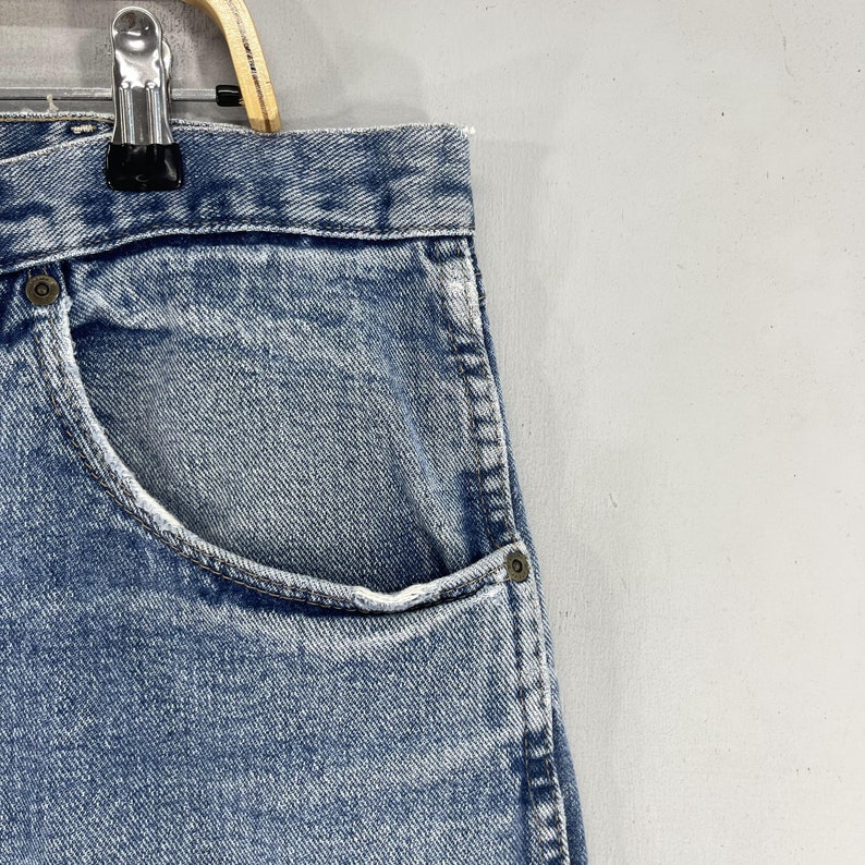May include: A pair of light blue denim jeans with a front pocket. The jeans have a faded look and are made of a soft, comfortable material.