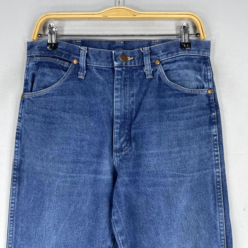 K&ouml;nnte beinhalten: Eine blaue Jeanshose im klassischen 5-Pocket-Stil. Die Jeans hat eine hohe Taille und ein gerades Bein.