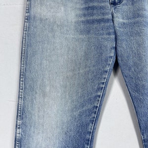 May include: A pair of light blue denim jeans with a faded wash. The jeans have a straight leg and a classic five-pocket style.