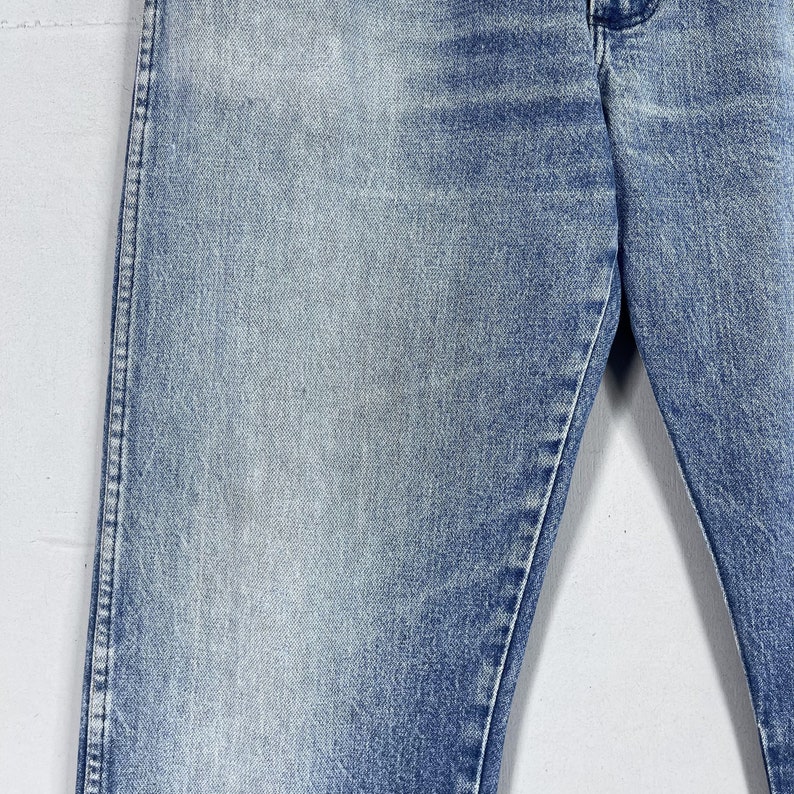 May include: A pair of light blue denim jeans with a faded wash. The jeans have a straight leg and a classic five-pocket style.