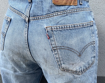 Może przedstawiać: Jasnoniebieskie dżinsy z denimu z brązową skórzaną naszywką z napisem "Levi Strauss & Co. Original riveted quality clothing" i "550" oraz metką z rozmiarem "W36 L30".