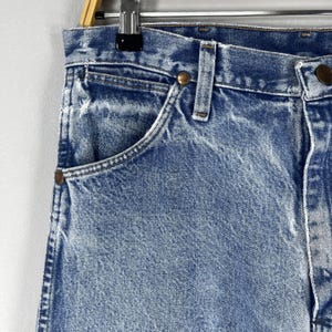 Pu&ograve; includere: Jeans in denim blu chiaro con un aspetto sbiadito e una singola tasca anteriore. I jeans hanno uno stile classico a cinque tasche.