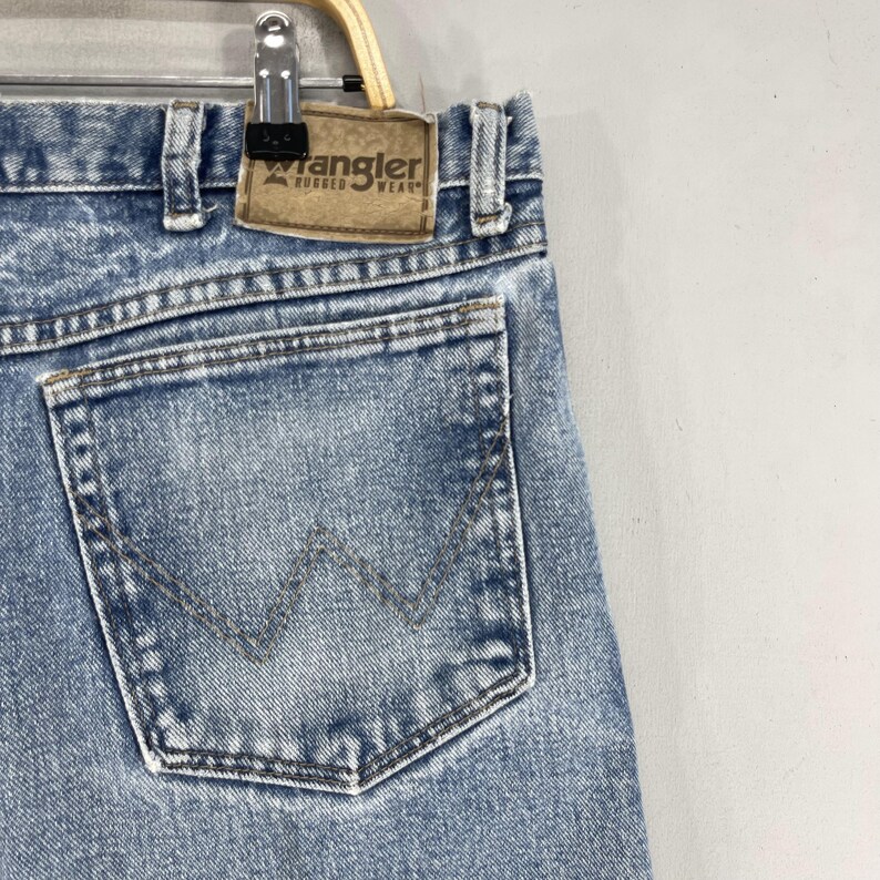 May include: A pair of light blue denim jeans with a back pocket featuring a distinctive
