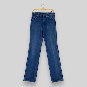 K&ouml;nnte beinhalten: Eine blaue Jeans aus Denim, die an einem Holzb&uuml;gel h&auml;ngt. Die Jeans hat einen klassischen geraden Schnitt und ist aus strapazierf&auml;higem Baumwollgemisch gefertigt.
