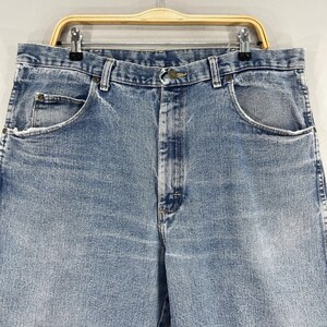 May include: A pair of light blue denim jeans with a button fly and five pockets.