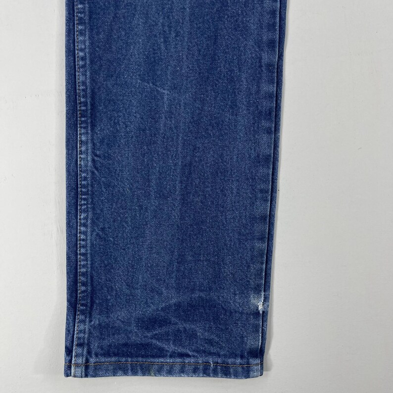 K&ouml;nnte beinhalten: Nahaufnahme des unteren Teils einer blauen Jeans. Die Jeans hat einen geraden Schnitt und eine klassische Passform.