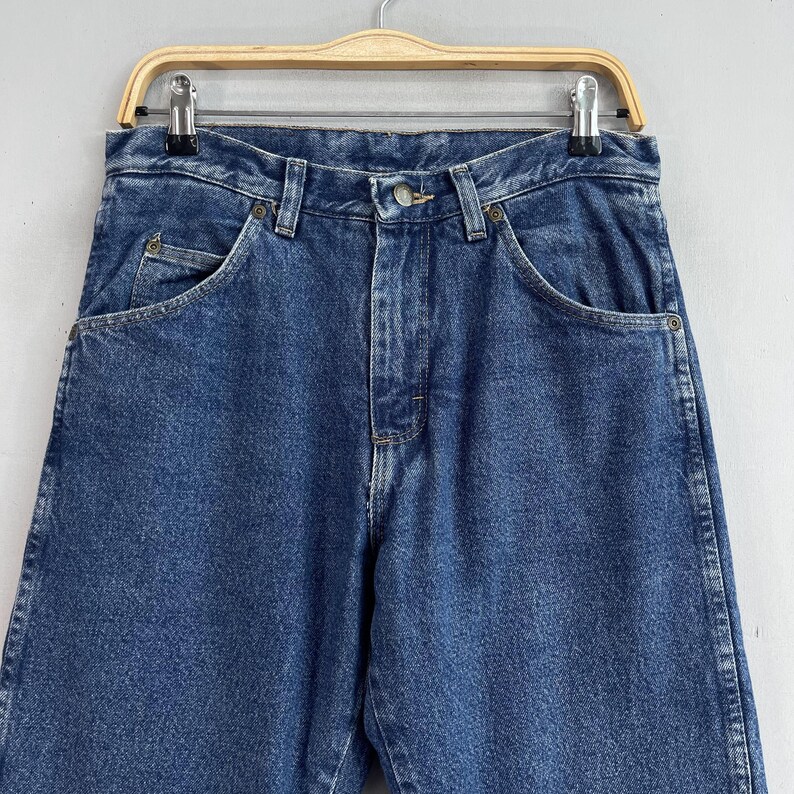 May include: A pair of blue denim jeans with a classic five-pocket style. The jeans have a straight leg and a relaxed fit.