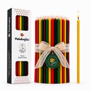 May include: A collection of colorful beeswax candles, bundled and tied with a beige ribbon. A single lit yellow candle stands beside the bundle. The packaging includes the brand name "Petekoğlu" and the words "Natural Beeswax Candle."