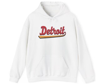 Peut inclure: Sweat-shirt à capuche blanc avec une poche avant et un cordon de serrage. Le mot "Detroit" est imprimé sur la poitrine en écriture rouge avec une ombre jaune et noire.