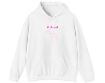Peut inclure: Sweat à capuche blanc avec une poche avant et un cordon de serrage. Le design présente le mot "Detroit" au-dessus d'un contour rose de l'État du Michigan.