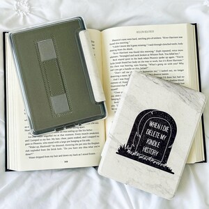 May include: A white and black marble patterned Kindle cover with the text "When I die delete my Kindle history" in black lettering.