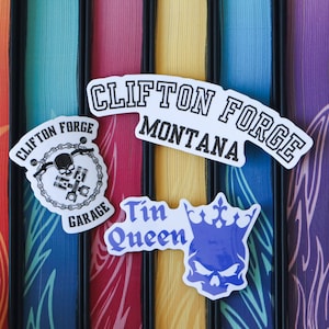 Puede incluir: Tres pegatinas sobre un fondo colorido. La primera pegatina es una calavera en blanco y negro con una cadena y el texto "Clifton Forge Garage". La segunda pegatina es blanca con texto negro que dice "Clifton Forge Montana". La tercera pegatina es blanca con texto negro que dice "Tin Queen" y una calavera morada con una corona.