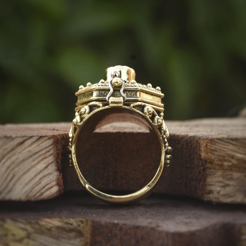 This is a gold poison ring with a garnet stone.