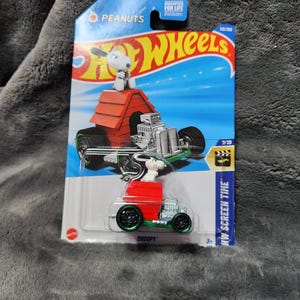 Op de afbeelding: Een witte keramische mok met een zwart handvat en de tekst "But First, Coffee" in een zwarte, handgeschreven lettertype. De mok staat op een wit oppervlak.