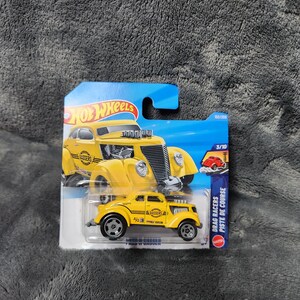 以下が含まれることがあります： 青と白のカードに「Gassers」とラベルされた黄色のホットウィールダイキャストおもちゃの車。車は黒い車輪と「Drag Racers」の文字が特徴です。パッケージには、Hot Wheelsのロゴと番号「3/10」が含まれています。