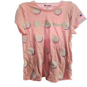 Puede incluir: Camiseta rosa Champion con lunares blancos y el logo Champion en verde claro. La camiseta tiene mangas cortas y cuello redondo. El logo Champion está bordado en el pecho. La camiseta es talla XL.