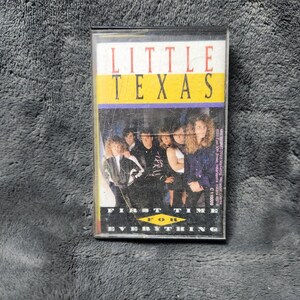 May include: A vintage cassette tape for the album "First Time for Everything" by Little Texas. The cassette case has a white, yellow, and purple design with a photo of the band. The text "LITTLE TEXAS" is at the top.
