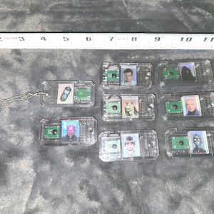 Puede incluir: Nueve llaveros de plástico transparente con diferentes imágenes de personajes de la franquicia Star Wars. Cada llavero tiene un pequeño cuadrado verde con una imagen de personaje y un cuadrado más grande con un retrato de personaje. Los personajes incluyen Yoda, Darth Vader, Chewbacca, R2-D2, C-3PO, Luke Skywalker, la princesa Leia, Han Solo y Boba Fett.