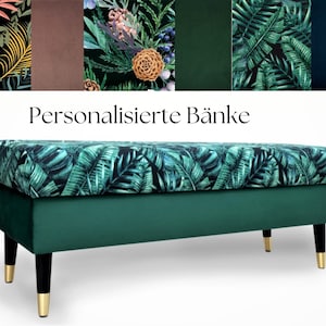 Op de afbeelding: Een groene bank met een tropisch bladerpatroon op het zitkussen. De bank heeft een effen groene basis, zwarte poten met goudkleurige uiteinden en de tekst "Personalisierte Bänke" erboven.