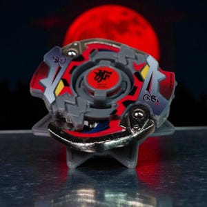 May include: A gray, red, and silver spinning top toy with a circular design. The top has a red center with Japanese characters and is set against a dark background with a red moon.