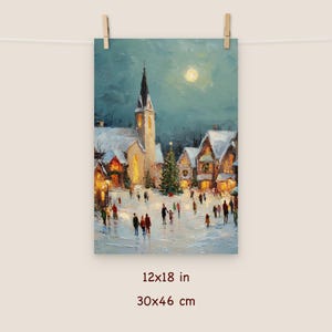 May include: A winter scene print depicting a snow-covered village square with a church, houses, and a Christmas tree. The artwork, measuring 12x18 inches, features figures of people and a full moon in a teal sky. The print is hung with wooden clips.