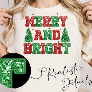 May include: White t-shirt with red and green glitter lettering that reads "Merry and Bright". The letters are outlined in white. The shirt has a festive Christmas theme.