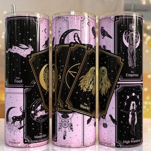 May include: Three stainless steel tumblers with pink and black glitter designs featuring tarot card imagery. The cards include The Fool, The World, The Empress, The High Priestess, The Magician, The Emperor, The Hierophant, and Justice.