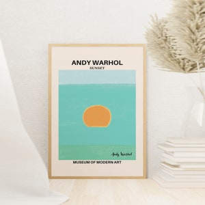 May include: A minimalist poster with a light blue and green background featuring a yellow sun. The poster is titled "Andy Warhol Sunset" and includes the text "Museum of Modern Art".