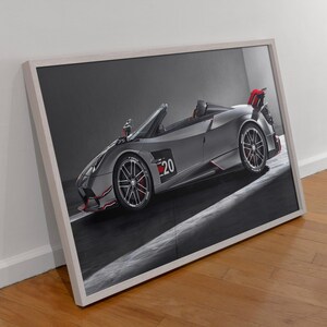 May include: A framed print of a silver convertible sports car with the number 20 on the side. The car has red accents on the wheels and rear spoiler. The image is set against a gray background.