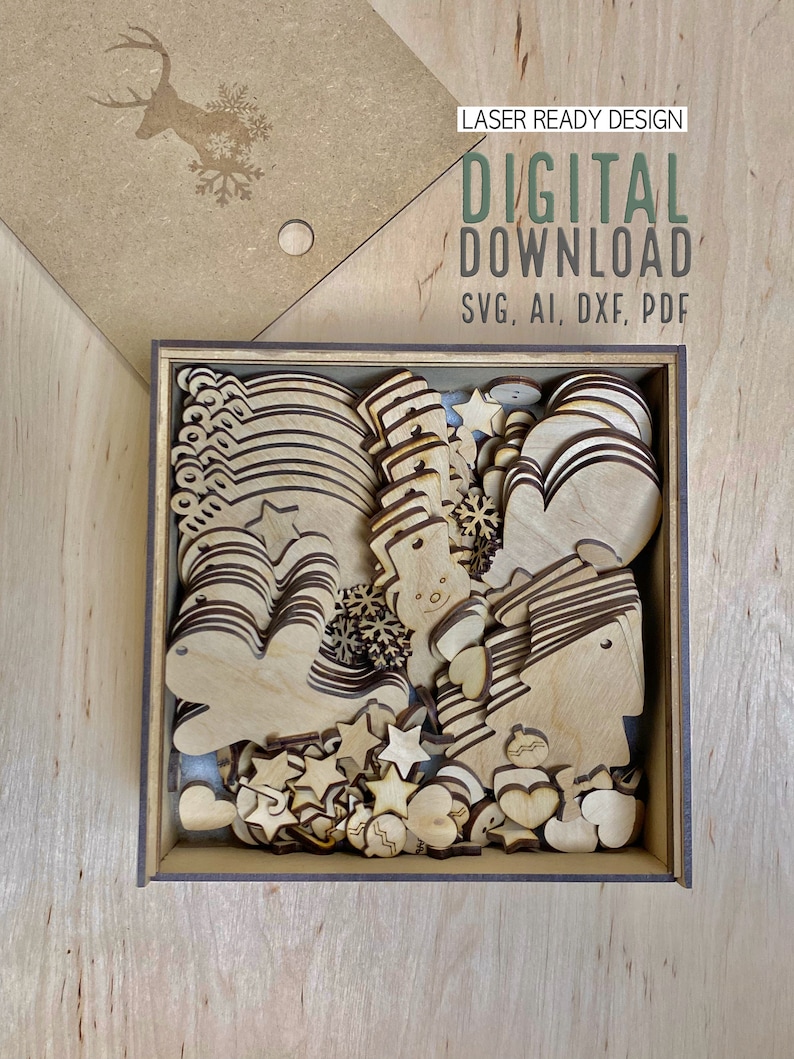 May include: A wooden box filled with laser-cut Christmas ornaments in various shapes, including stars, hearts, snowmen, and mittens. The box is open, revealing the contents. The lid features a deer and snowflake design. Text on the lid reads "LASER READY DESIGN" and "DIGITAL DOWNLOAD".