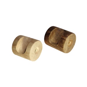 May include: Two wooden knobs with a cylindrical shape and a cutout on one side. The knobs are made of different types of wood, one is light brown and the other is dark brown.