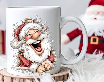 Op de afbeelding: Witte keramische mok met een cartoon kerstman die door een bakstenen muur breekt. De kerstman draagt een rood pak en hoed, met een lange witte baard en een vrolijke uitdrukking. De mok heeft een gebogen handvat.