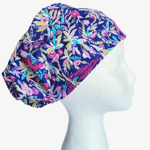 May include: A blue scrub hat with a floral print featuring pink, green, and white flowers and birds.